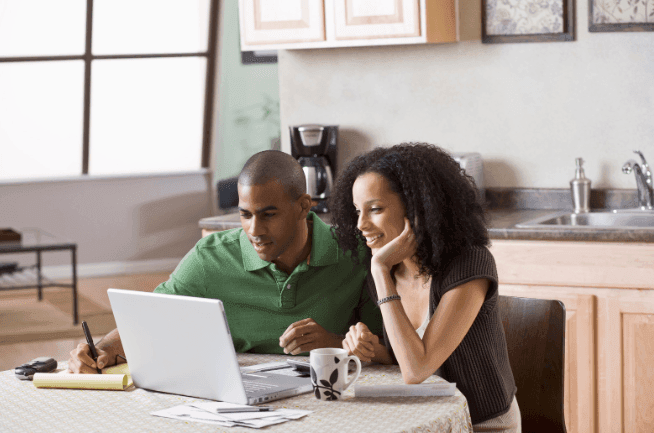 Couple using laptop in kitchen