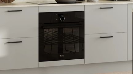 Built under matt black oven in a kitchen with handles