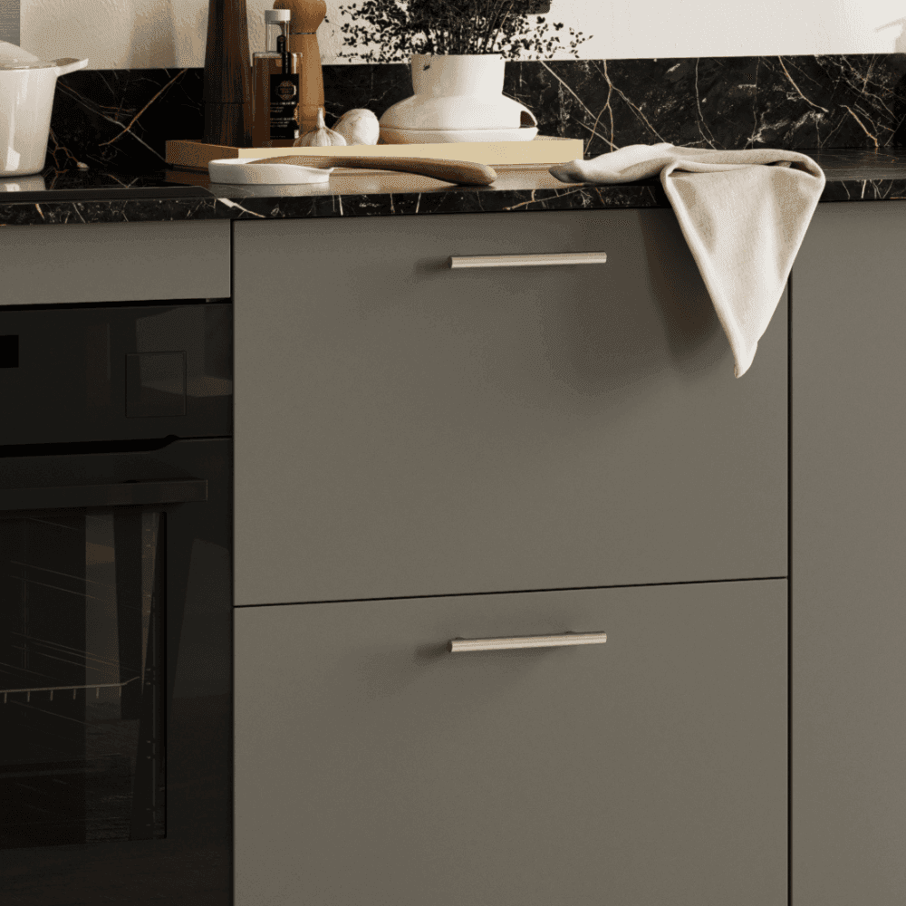 Close up of dark grey slab doors with handles and black worktop