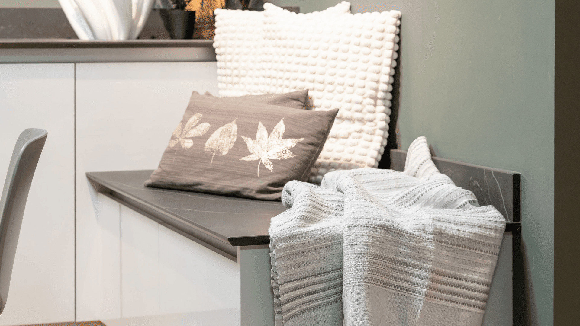 Cushions and a throw placed on low seating in the kitchen