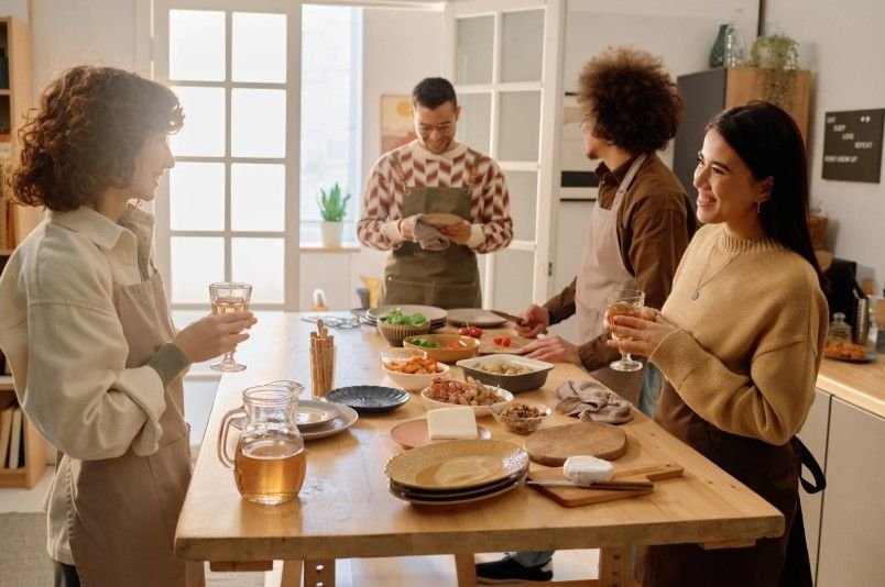 People in kitchen entertaining friends around a table
