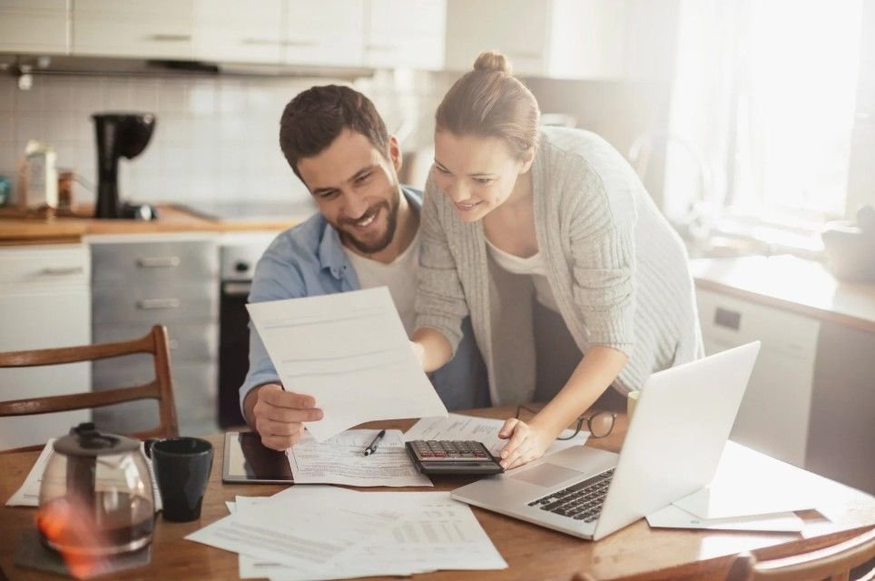A couple looking at paper budgeting their kitchen