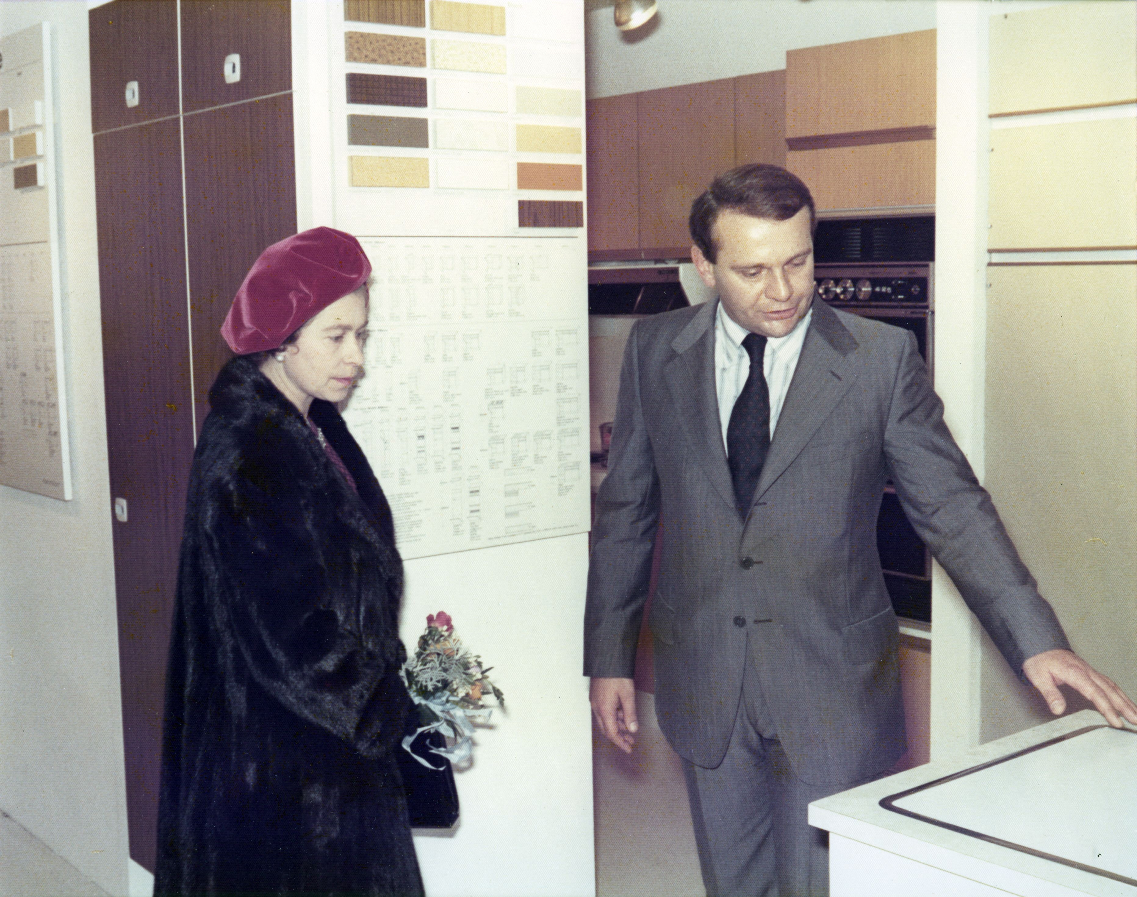 Queen Elisabeth II visiting showroom and being shown kitchen